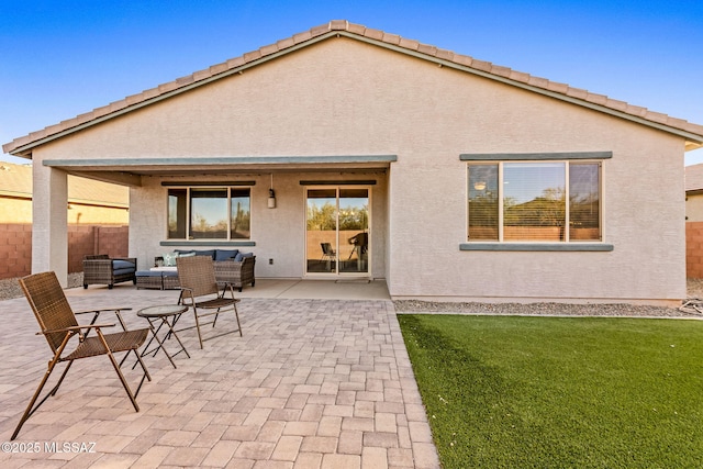 back of property featuring an outdoor living space, a patio area, and stucco siding