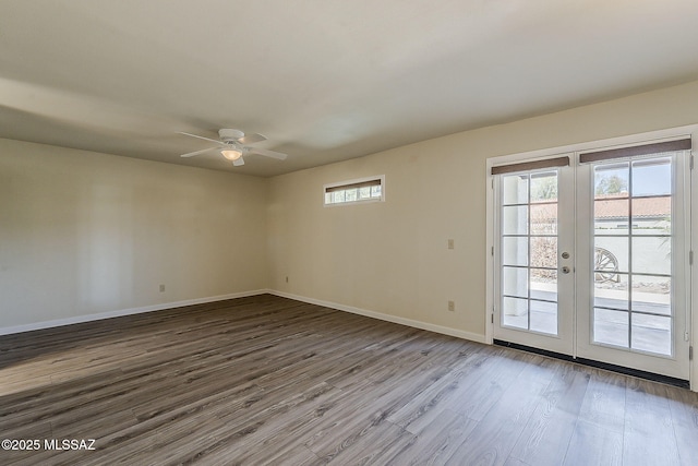 unfurnished room featuring french doors, wood finished floors, baseboards, and ceiling fan