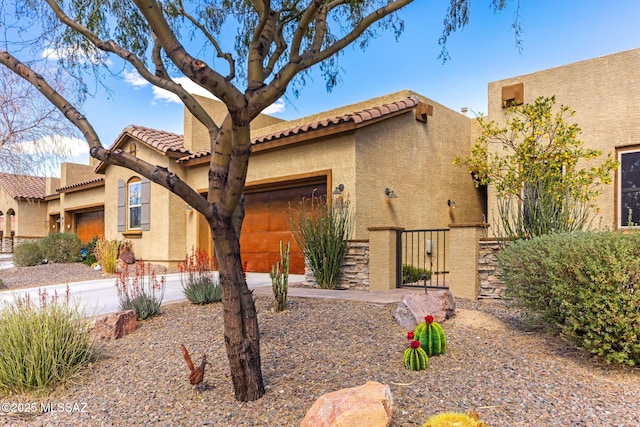 view of front of property featuring a garage, stucco siding, a tiled roof, and concrete driveway