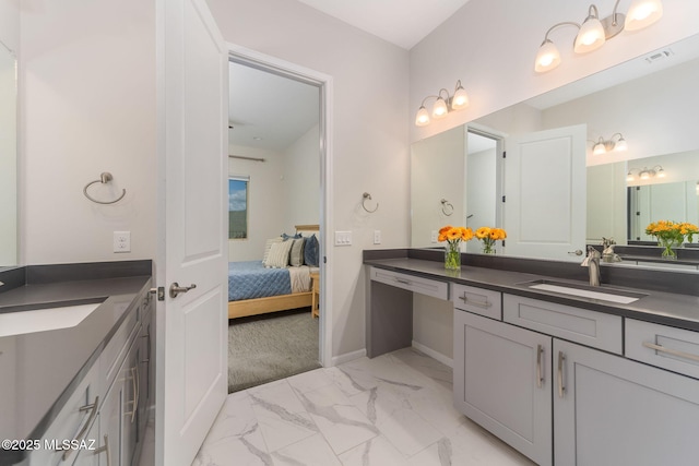 ensuite bathroom with visible vents, baseboards, ensuite bathroom, marble finish floor, and vanity