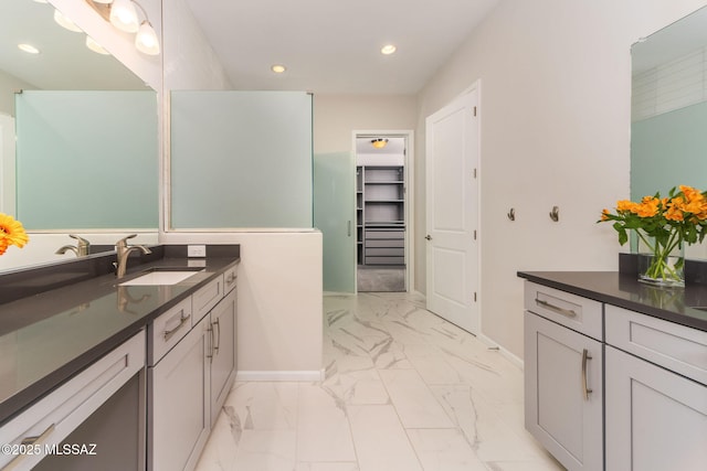bathroom with a walk in closet, vanity, marble finish floor, recessed lighting, and baseboards