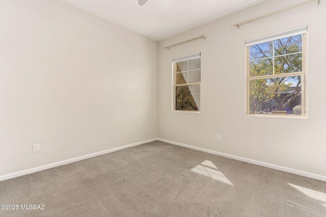 spare room with carpet flooring, baseboards, and ceiling fan