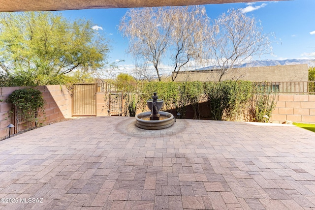 view of patio / terrace featuring a gate, a mountain view, and fence