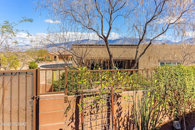 exterior space with a mountain view, a vegetable garden, and fence