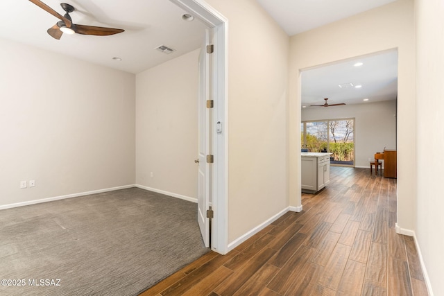 corridor featuring recessed lighting, visible vents, baseboards, and dark wood-style floors