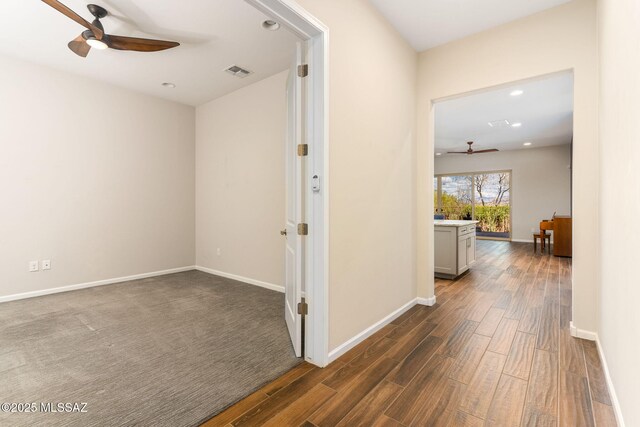 hallway with recessed lighting, baseboards, visible vents, and dark wood finished floors