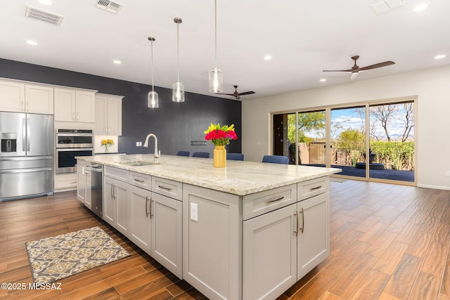 kitchen featuring visible vents, a sink, appliances with stainless steel finishes, and a ceiling fan