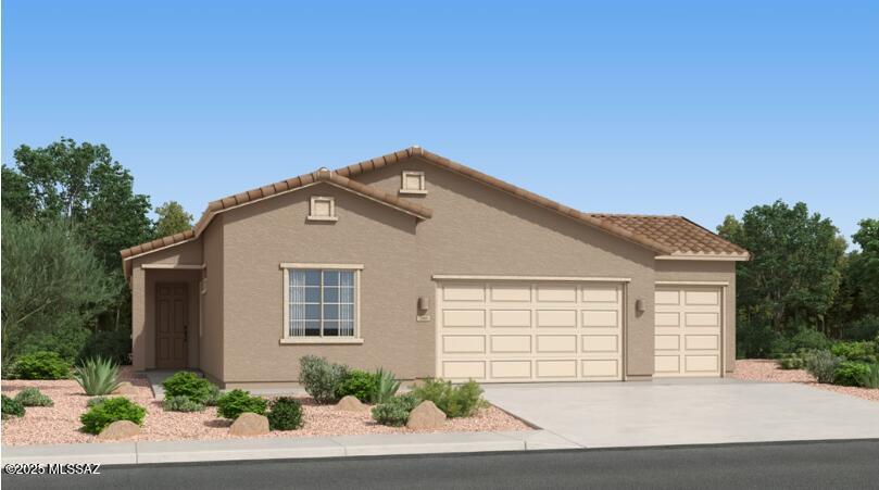 view of front of property featuring a tile roof, an attached garage, driveway, and stucco siding