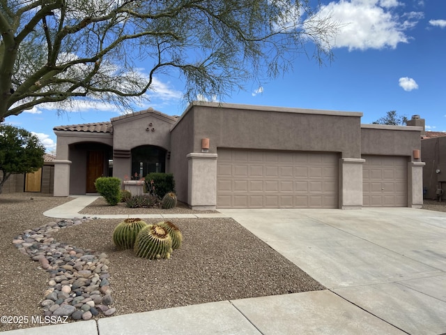 view of front facade with a tile roof, stucco siding, an attached garage, and concrete driveway