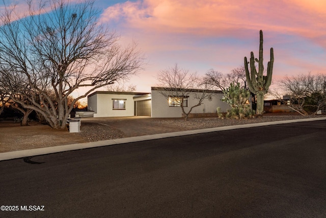 view of front of house with stucco siding, driveway, and a garage