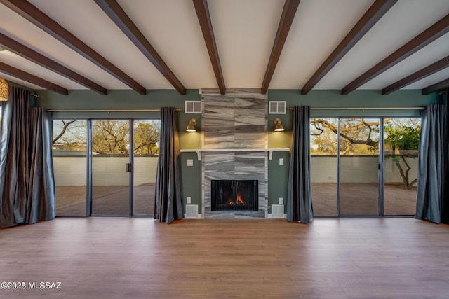 unfurnished living room with a wealth of natural light, visible vents, and a high end fireplace