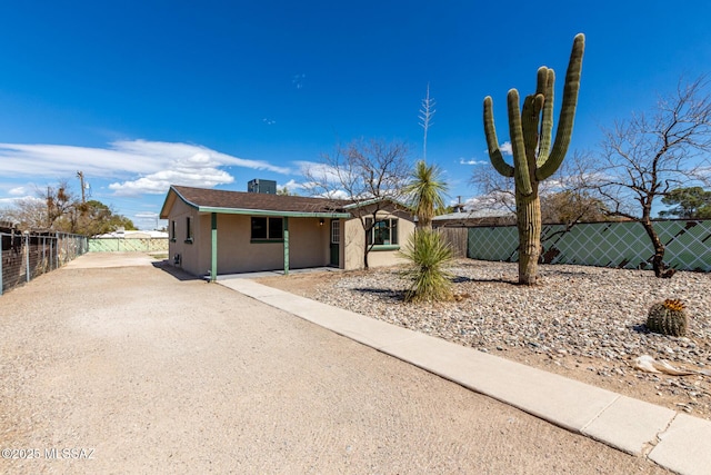 view of front of home with stucco siding and fence