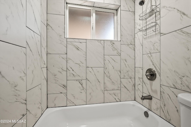 bathroom featuring shower / washtub combination and toilet