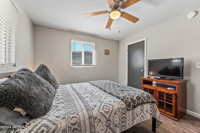 bedroom with wood finished floors, baseboards, and ceiling fan