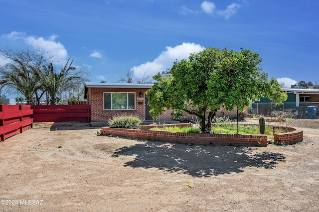 view of front of property featuring brick siding and fence