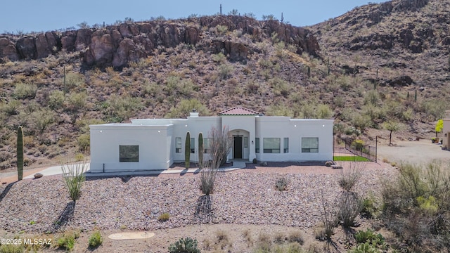 view of front of property featuring a chimney, a mountain view, and stucco siding