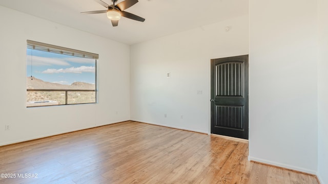 unfurnished room with light wood-type flooring, baseboards, and a ceiling fan