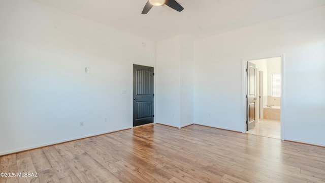 spare room with baseboards, a ceiling fan, and light wood finished floors