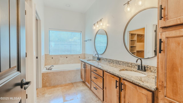 full bath with a garden tub, double vanity, and a sink