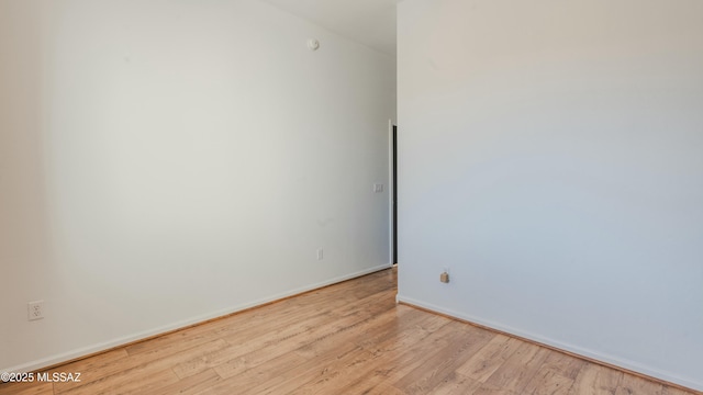 unfurnished room featuring baseboards and wood finished floors