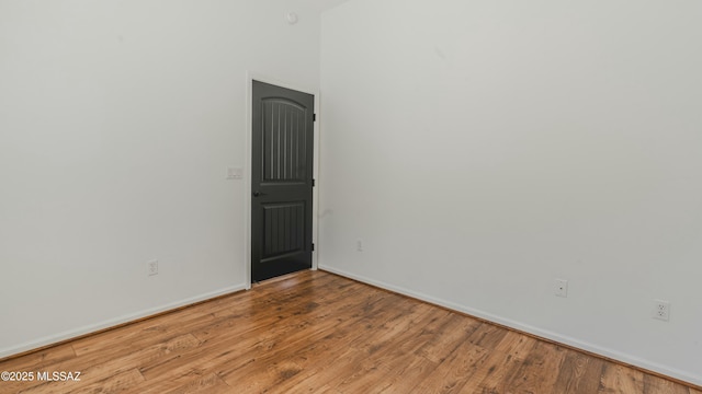 empty room featuring baseboards and wood finished floors