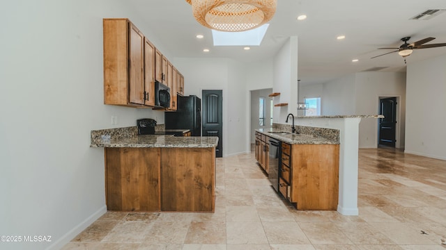 kitchen featuring visible vents, a peninsula, brown cabinetry, black appliances, and a sink