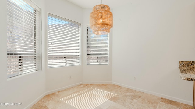 tiled spare room featuring baseboards and a healthy amount of sunlight