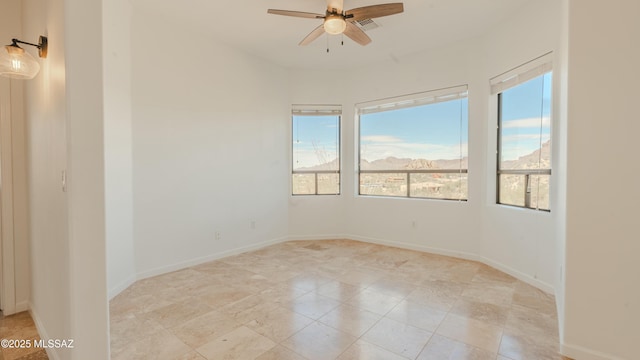 spare room featuring visible vents, baseboards, and ceiling fan