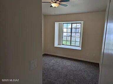 unfurnished room with a ceiling fan and baseboards