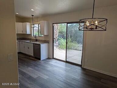 kitchen featuring a chandelier, white cabinets, dark wood-type flooring, and a sink