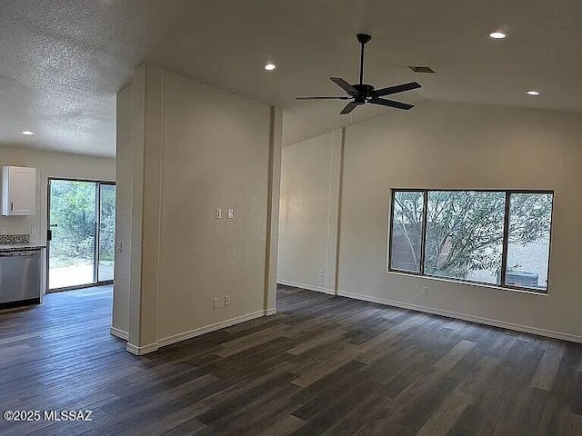 spare room featuring dark wood finished floors, a textured ceiling, a ceiling fan, and vaulted ceiling