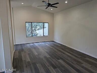 spare room with dark wood finished floors, vaulted ceiling, recessed lighting, and a ceiling fan