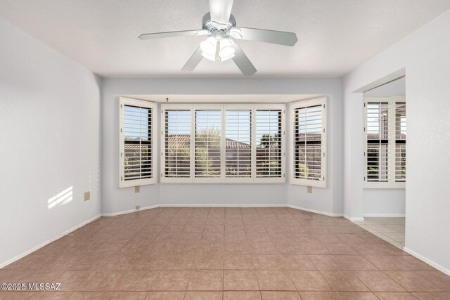 unfurnished room featuring light tile patterned floors, baseboards, and ceiling fan