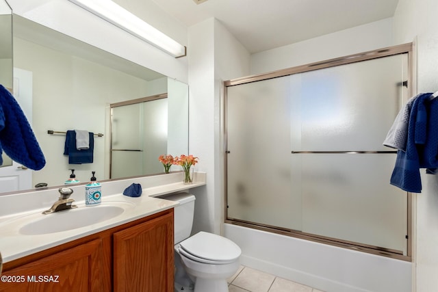 bathroom with toilet, tile patterned floors, bath / shower combo with glass door, and vanity