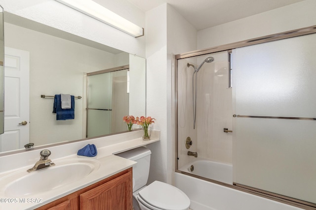bathroom with vanity, toilet, and shower / bath combination with glass door