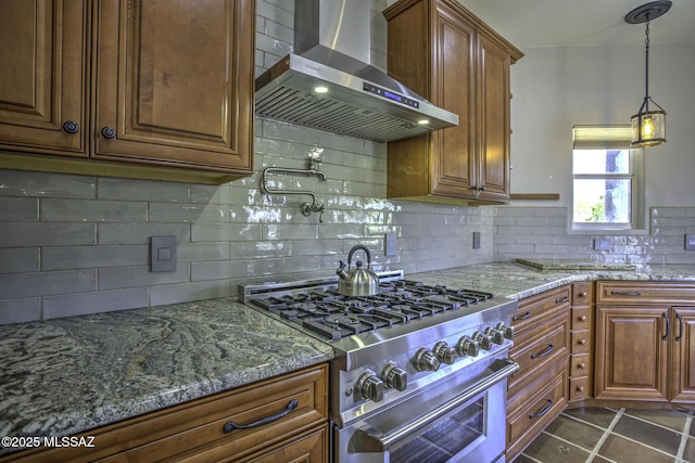 kitchen with brown cabinetry, light stone countertops, decorative backsplash, high end stainless steel range oven, and wall chimney exhaust hood