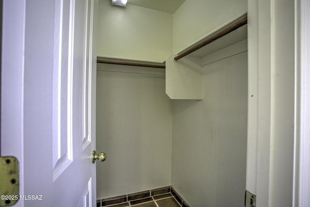 spacious closet featuring dark tile patterned floors