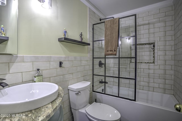 bathroom featuring vanity, tile walls, toilet, and combined bath / shower with glass door