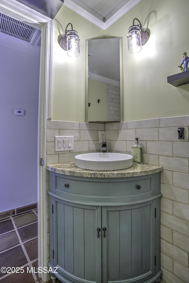 bathroom with vanity, tile walls, a wainscoted wall, and ornamental molding