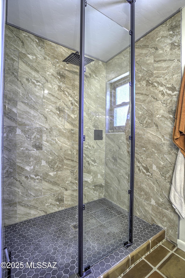 full bath with a shower stall and tile patterned floors