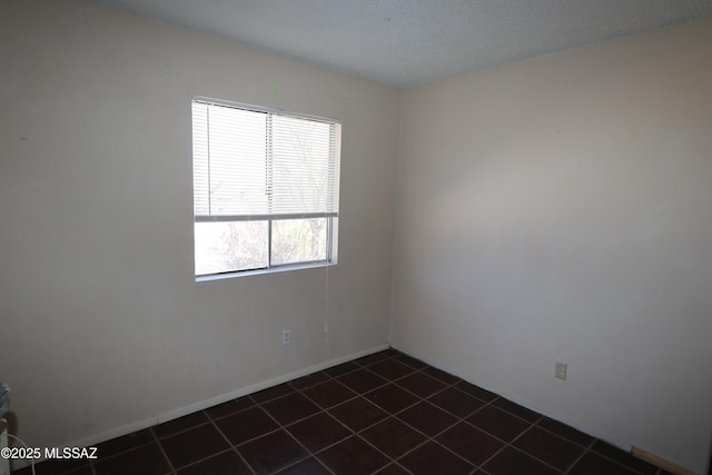 spare room with dark tile patterned flooring