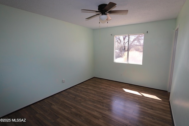 spare room with a ceiling fan, dark wood finished floors, and a textured ceiling