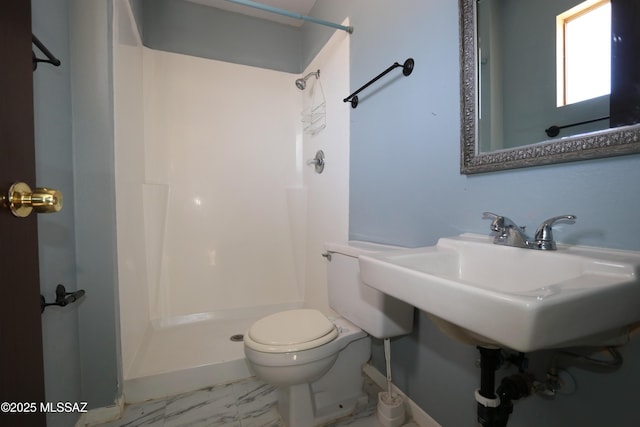 bathroom with a shower stall, toilet, and marble finish floor