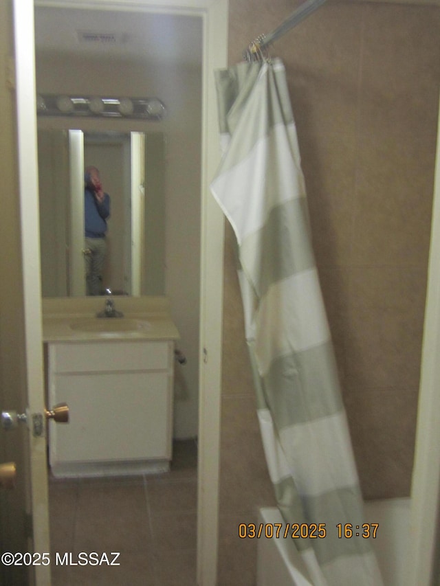 bathroom featuring tile patterned flooring, vanity, and shower / tub combo with curtain