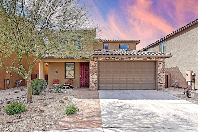 view of front of home with a tile roof, concrete driveway, stucco siding, stone siding, and an attached garage