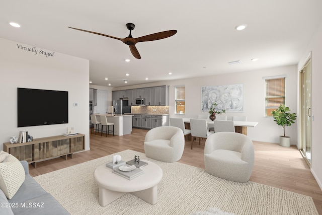 living area featuring recessed lighting, ceiling fan, and light wood-style floors