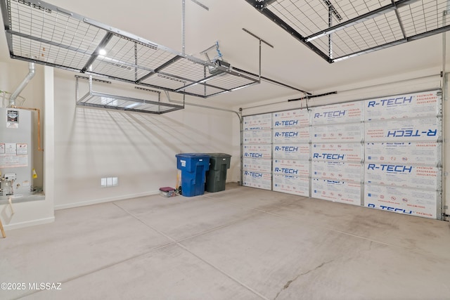 garage with gas water heater, a garage door opener, and baseboards