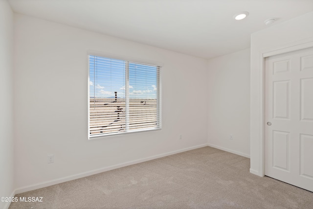 carpeted empty room featuring baseboards