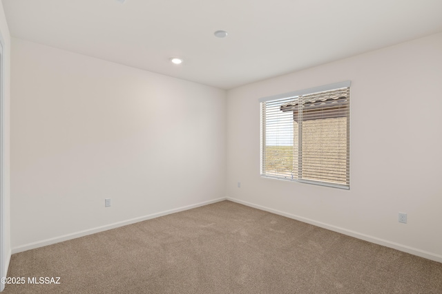 carpeted empty room featuring recessed lighting and baseboards