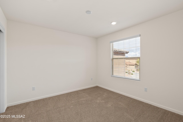 carpeted empty room featuring recessed lighting and baseboards